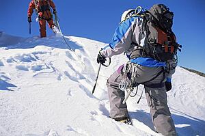 Two mountain climbers walking in snow (selective focus)