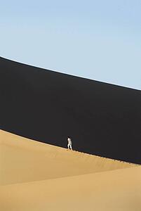 Man outdoors walking in the desert (far away)