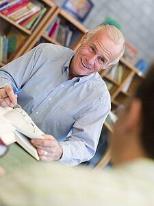 Two men in library with notepads talking (selective focus)