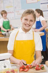 Female student slicing berries in cooking class
