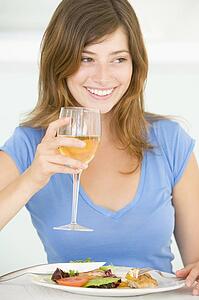 Young Woman Enjoying meal, mealtime With A Glass Of Wine