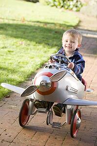 Young boy playing outdoors in airplane smiling