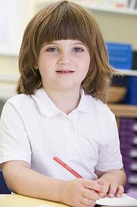 Student in class writing in notebook (selective focus)