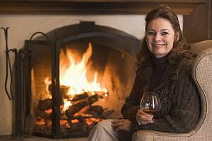 Woman in living room with drink smiling