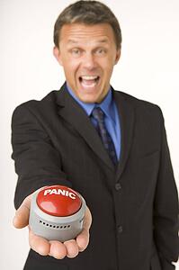 Businessman Holding A Panic Button 