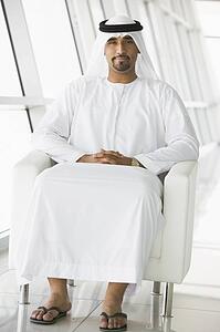 Man sitting indoors smiling (high key/selective focus)