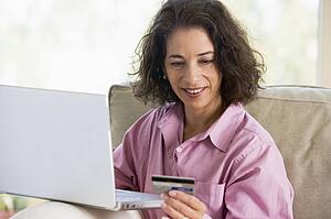 Woman with a laptop computer making an online purchase with credit card