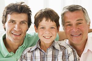 Grandfather with son and grandson smiling.