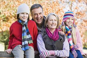 Grandparents with grandchildren outdoors at park smiling (selective focus)