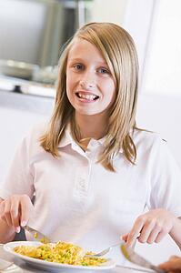 Student in cafeteria eating lunch (selective focus)