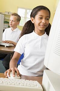 Student at computer terminal with student in background (selective focus)