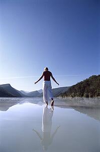Woman outdoors walking on water in scenic location
