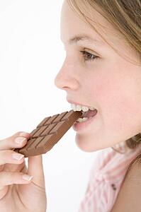Teenage girl eating chocolate bar