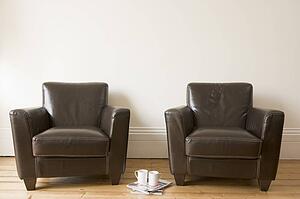 Two chairs with coffee mug and magazines between them
