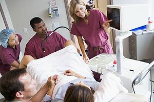 Doctor looking at monitor while retrieving eggs from ovary using vaginal ultrasound
