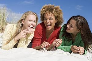 Three women posing on a sand hill