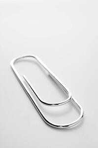 Close Up Of Silver Paperclip Against A White Background