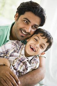 Father and son in living room smiling (high key)