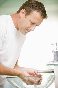 Man in bathroom washing hands