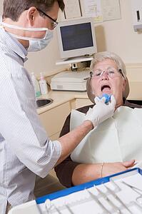 Dentist in exam room with woman in chair