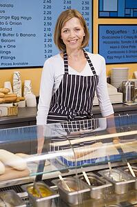 Woman standing at counter in restaurant smiling