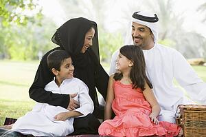 Family outdoors in park having a picnic and smiling (selective focus)