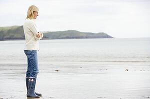 Woman standing on beach smiling