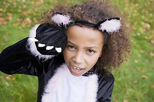Young girl outdoors in cat costume on Halloween
