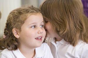 Two students in class whispering (selective focus)