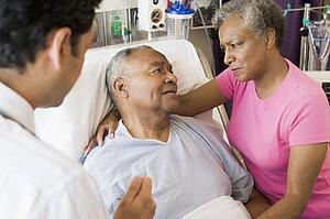Senior Couple Talking To Doctor, Looking Worried