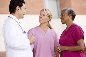 Doctor And Nurses Standing Outside A Hospital