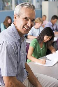 Students studying in geography class with teacher