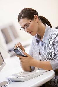 Woman in computer room using personal digital assistant