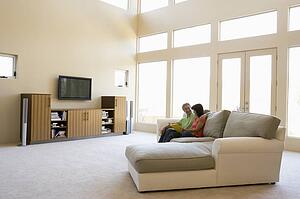 Couple reading book in living room smiling