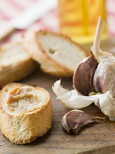 Cloves of Roasted Garlic spread on Toasted baguette