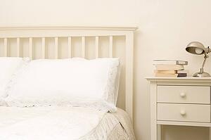Empty bedroom with books on nightstand