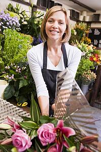 Woman working at flower shop smiling