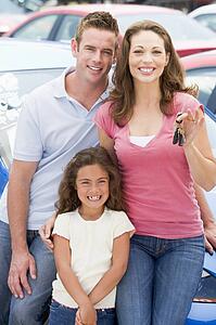 Mother Father and young daughter shopping for a new car