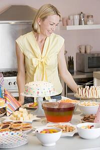 Woman at party standing by food table smiling