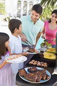 Family Enjoying A Barbeque