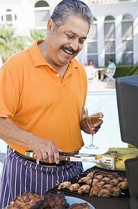 Man Barbequing In A Garden
