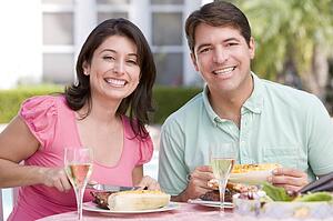 Couple Enjoying A Barbequed Meal In The Garden