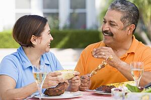 Couple Enjoying A Barbequed Meal In The Garden