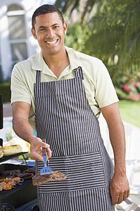 Man Barbequing In A Garden