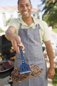 Man Barbequing In A Garden