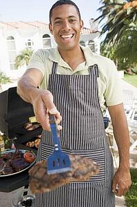 Man Barbequing In A Garden