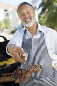 Man Barbequing In A Garden