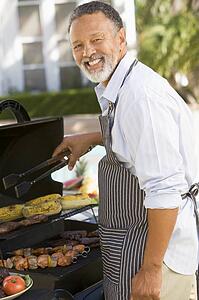 Man Barbequing In A Garden