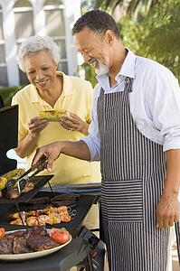 Couple Cooking On A Barbeque