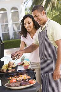 Couple Cooking On A Barbeque